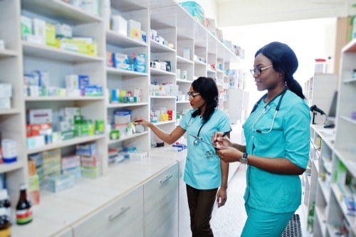 Two female African American pharmacists working behind the counter at a drugstore